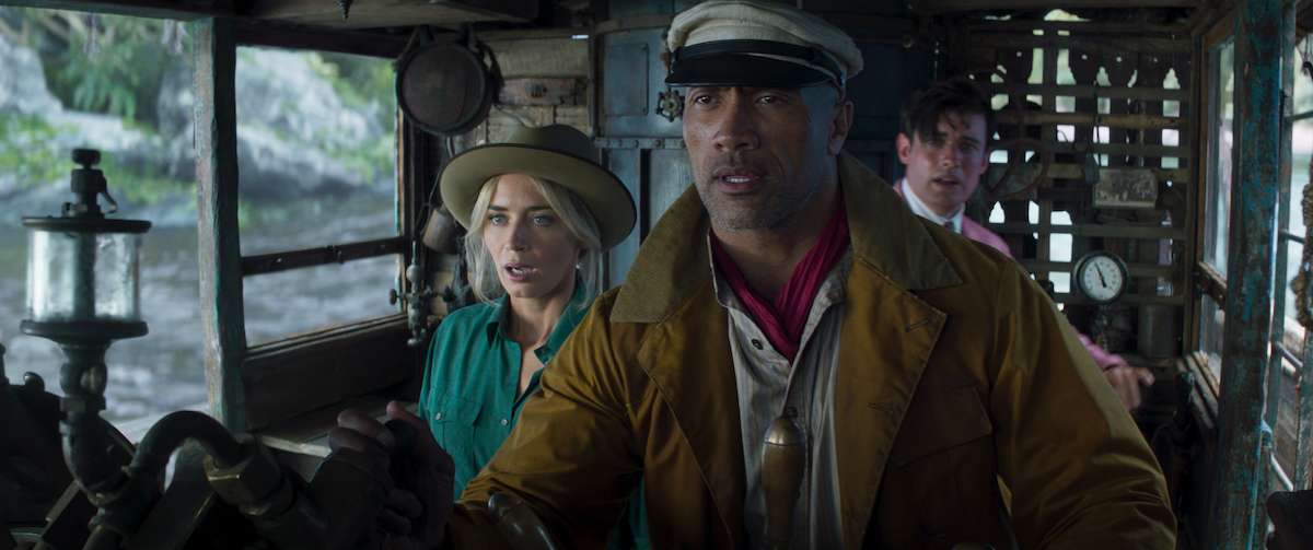 The lead cast of Jungle Cruise on the river boat, bracing to go over a massive water fall.